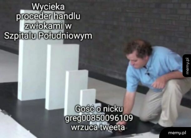 Mężczyzna przy białych prostokątnych blokach na czarnym tle.