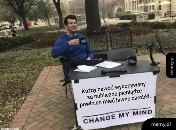 Mężczyzna siedzi przy stole z napisem i kubkiem.