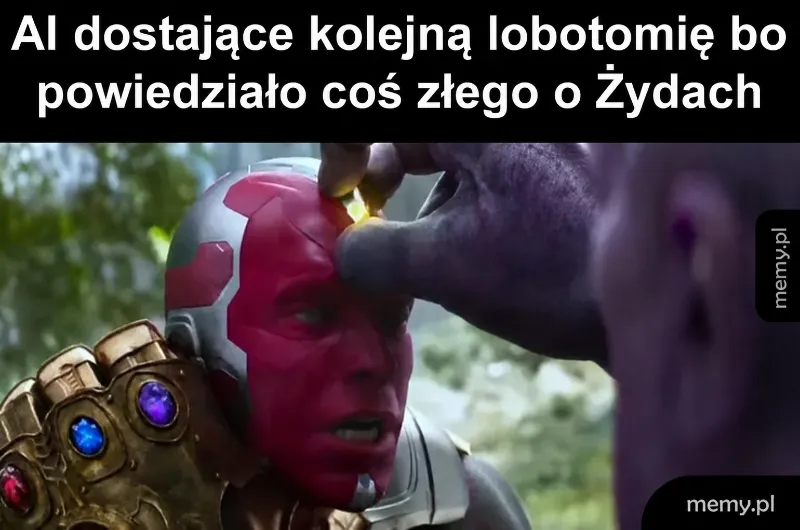 Postać z czerwonymi oczami i złotym kamieniem na czole, trzymana przez dużą postać z rękawicą.