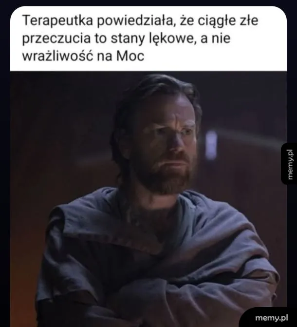 Mężczyzna z brodą w szarej szacie, z poważnym wyrazem twarzy.