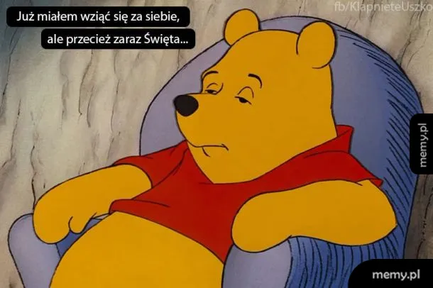 Kubuś Puchatek leży leniwie w fotelu.