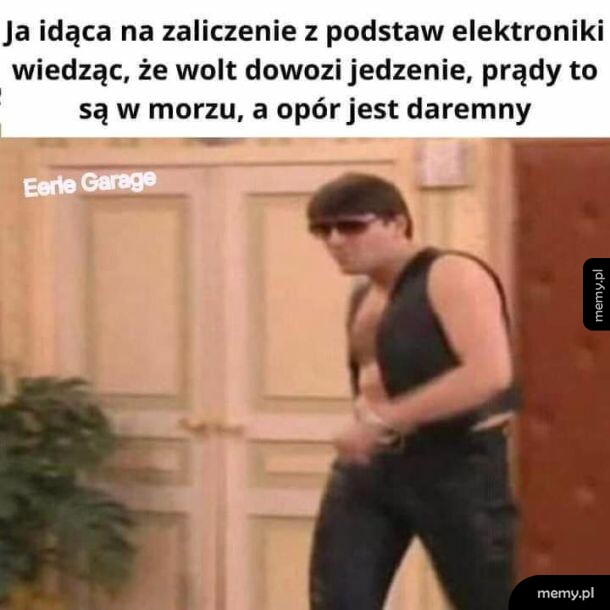 Mężczyzna w okularach słonecznych i kamizelce idzie korytarzem.