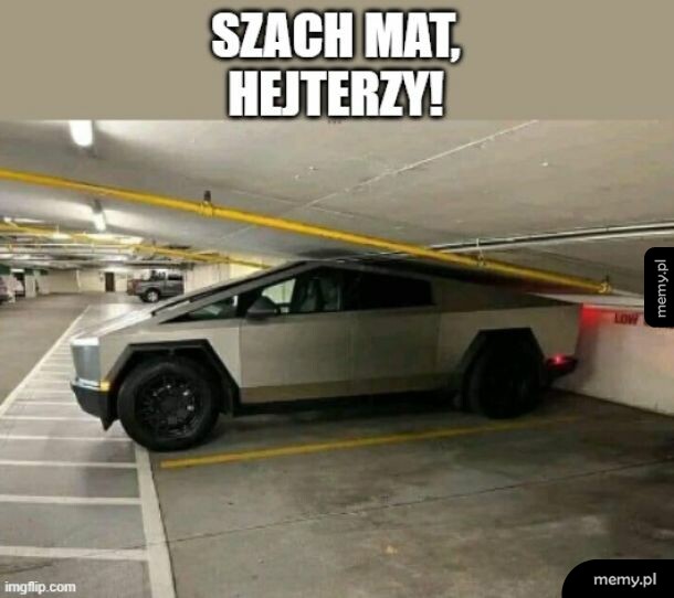 Tesla Cybertruck zaparkowana pod rurą na parkingu podziemnym.