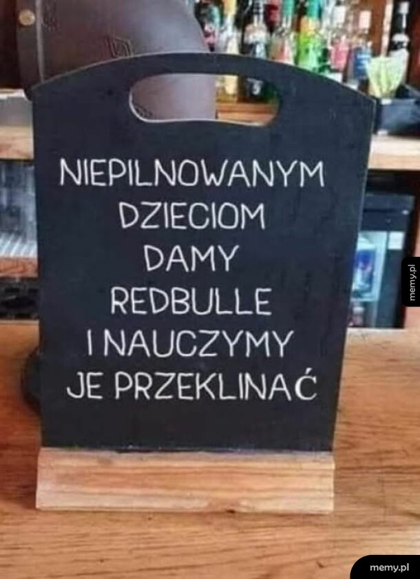 Czarna tablica kredowa z humorystycznym napisem o dzieciach w barze.